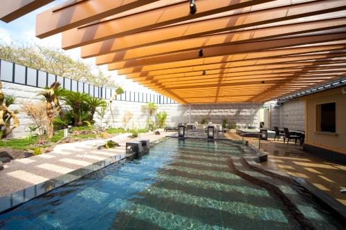 熊本其宽温泉域贝尔酒店的一座带木制天花板的建筑中的游泳池