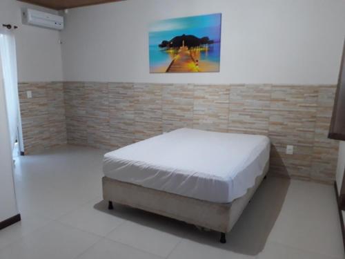 伊塔佩马Duplex com vista do mar!的砖墙间内一间卧室,配有一张床