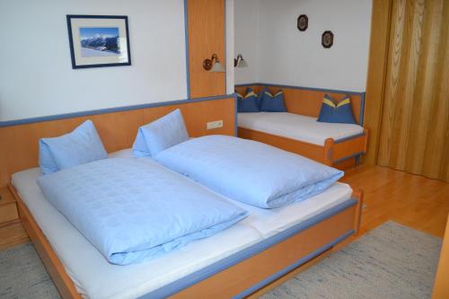图克斯安德烈亚斯霍费度假公寓的一间卧室配有两张带蓝色枕头的床。