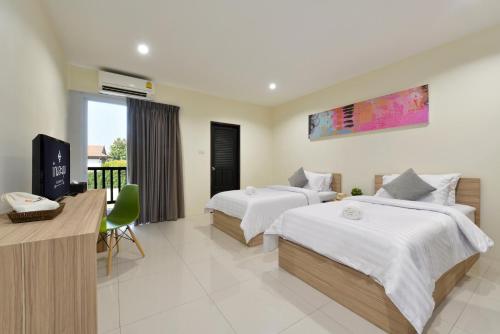 拉差汶里班拉姆恩酒店的酒店客房设有两张床和电视。