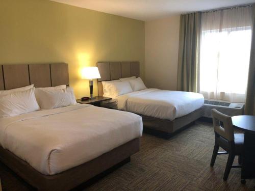 埃尔多拉多Candlewood Suites - El Dorado, an IHG Hotel的酒店客房设有两张床和一张桌子。