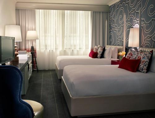 西雅图西雅图摩纳哥金普顿酒店的酒店客房设有两张床和电视。