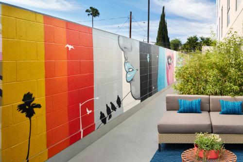 洛杉矶威尔希尔金普顿酒店的一张沙发旁墙上的彩色壁画