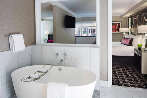 纽约The Muse New York的酒店客房设有浴缸和卧室。
