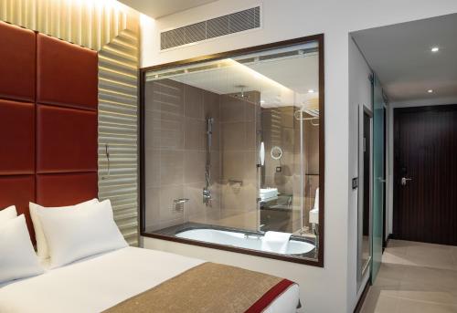 利雅德利雅得皇冠假日酒店 - RDC酒店与会议中心的一间带一张床的卧室和一间带浴缸的浴室