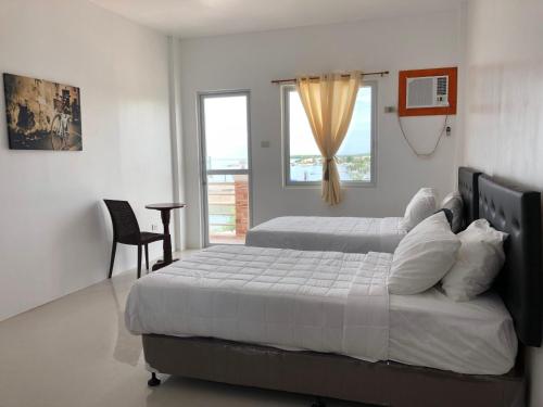 MayaArriyus Apartelle的一间卧室设有两张床和窗户。