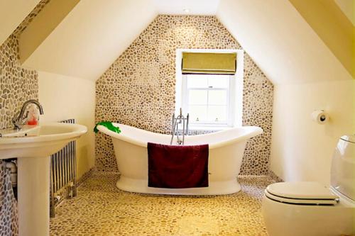 邓巴The Head Gardeners Cottage, Dunbar的一间带大浴缸和水槽的浴室