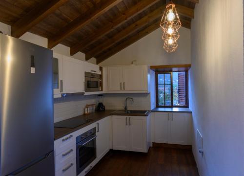 Los LlanillosCasa Rural Los Frailes的厨房配有白色橱柜和吊灯。