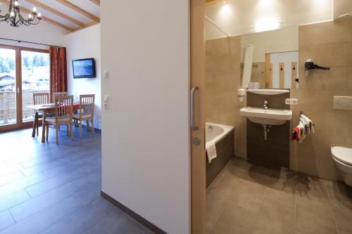 蒂罗尔州圣约翰诺伊尔旅馆的一间带水槽、卫生间和桌子的浴室