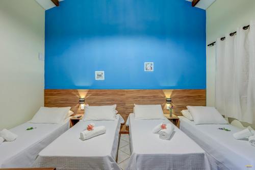 伊塔卡雷i9 Bem Bela Pousada的蓝色墙壁的房间的一排床位