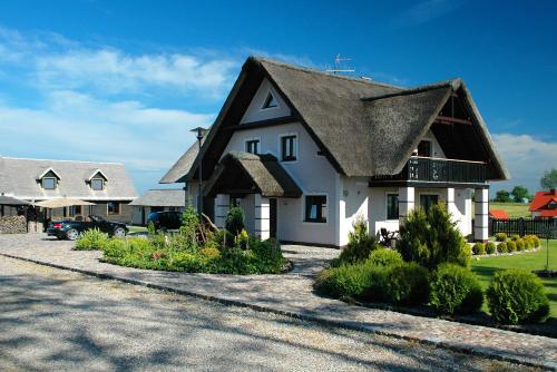达尔沃沃Pod Strzechą的一座带茅草屋顶的大型白色房屋