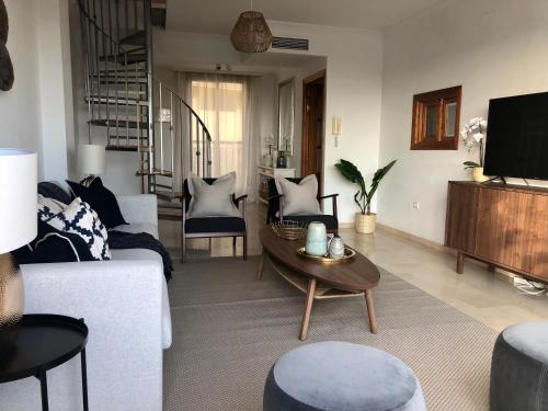 贝纳尔马德纳Luxurious duplex penthouse with golf and sea views的客厅配有白色的沙发和桌子