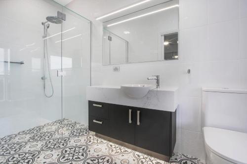 梅顿The Apartment, Metung的一间带水槽和玻璃淋浴的浴室