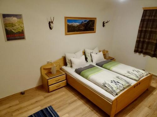 巴德加斯坦拉盖博乡村别墅公寓的一间卧室配有两张单人床和床头柜