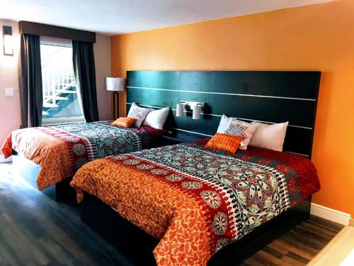 克利尔沃特Tropical Inn & Suites, downtown clearwater的酒店客房设有两张床和窗户。