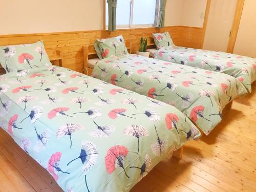 仙台HIBARI GUESTHOUSE的一间卧室配有两张床,上面有蒲公英