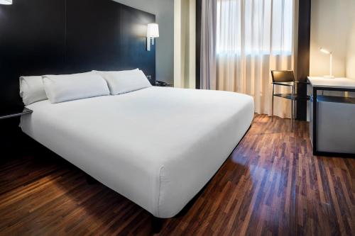 赫塔费B&B HOTEL Madrid Getafe的一张大白色的床,位于酒店客房内