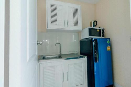 黎逸府Mae On Village Resort的厨房配有水槽、微波炉和冰箱