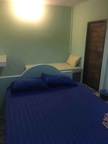 拉差汶里Bangkado Resort的一间卧室配有蓝色的床和长凳