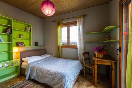 阿迪斯普普伦Diktamos Villas的一间卧室设有绿色的架子、一张床和一张桌子