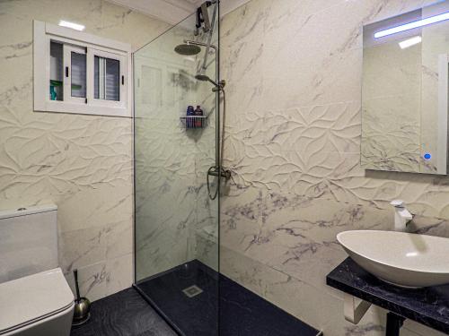 拉克鲁斯完美公寓的一间带玻璃淋浴和水槽的浴室