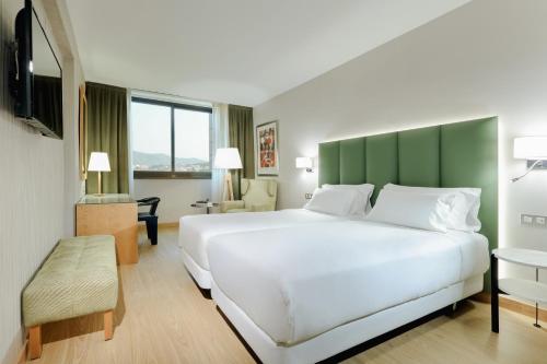 圣胡斯托德斯韦尔恩Hesperia Barcelona Sant Just的一间卧室配有一张白色大床和绿色床头板