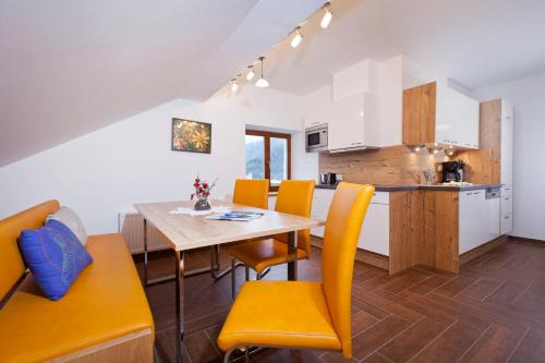 瑙德斯Alpenapart Marina的厨房以及带桌椅的用餐室。