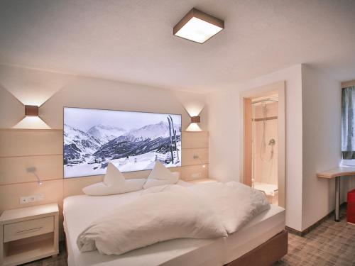 索尔登Glanzer Homes Hochsölden的卧室配有白色的床,墙上配有电视