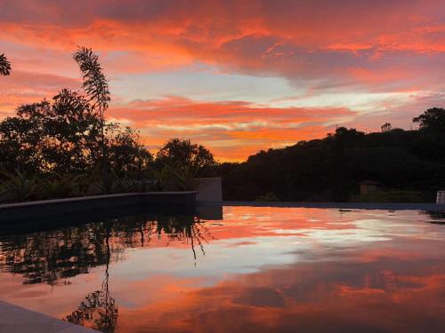 布希奥斯Pousada Villa Canaã的日落时分,在游泳池边欣赏天空
