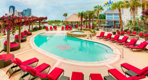 伯锡尔城Margaritaville Resort Casino的一个带红色躺椅的游泳池,一个度假村