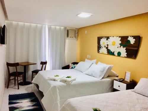 安格拉杜斯雷斯Pousada Costão do Sol的酒店客房设有两张床和一张桌子。