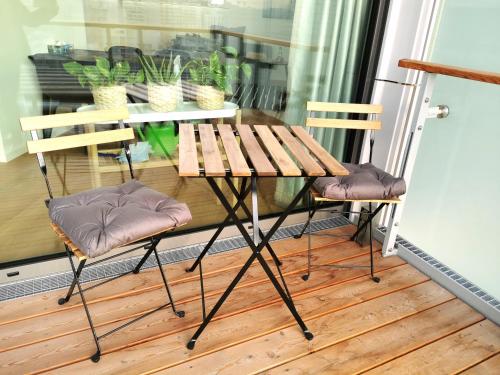 维也纳Apartment am Belvedere Vienna的阳台上配有一张木桌和两把椅子