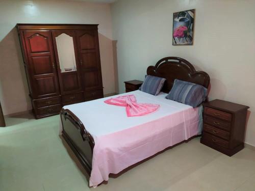 塔拉法尔Casa Cabral : Big Apartment next to the beach的一间卧室配有一张大床,上面有粉红色的弓