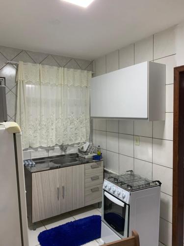 弗洛里亚诺波利斯Apartamento na Praia dos Ingleses的一间带水槽和炉灶的小厨房