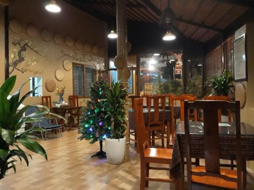 宁平An Phu's Garden House的一间设有桌椅和圣诞树的餐厅