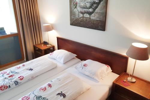 QuartenFerienwohnung Resort Walensee 98 - Seehöckli的配有白色床单的酒店客房内的两张床