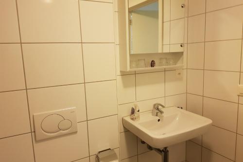 QuartenFerienwohnung Resort Walensee 98 - Seehöckli的白色的浴室设有水槽和镜子