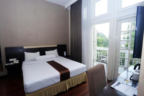 万隆万隆希莫纳克维奥酒店的一间卧室设有一张床和一个大窗户