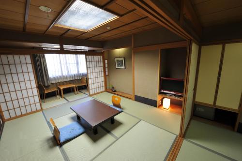 京都棉善酒店的客厅配有桌子和电视