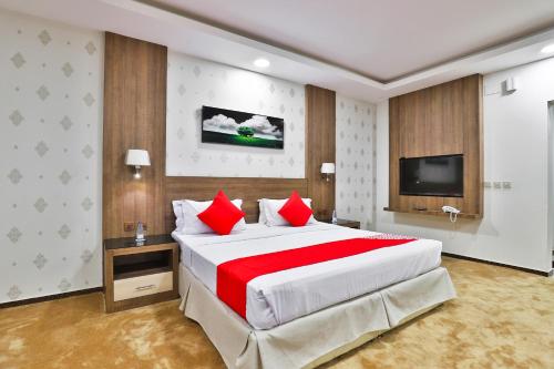 奈季兰نجمة نوارة للوحدات الفندقية的大卧室配有一张带红色枕头的大床