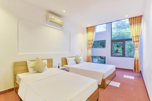 岘港Annie Danang Hotel & Apartment的一间卧室设有两张床和大窗户