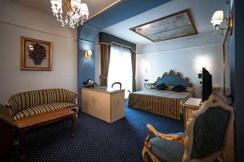 巴萨诺－德尔格拉帕博特美景酒店的一间卧室配有一张床、一张沙发和一把椅子