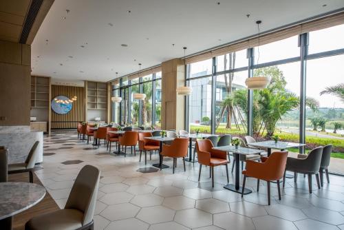 长沙长沙机场凯悦嘉轩酒店的餐厅设有桌椅和窗户。
