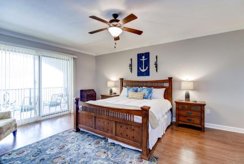 格尔夫波特Sleek Gulfport Condo with Ocean Views and Pool Access!的一间卧室配有一张床和吊扇