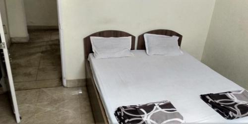 贾姆谢德布尔Adarsh lodge的一张床上有两个枕头的房间