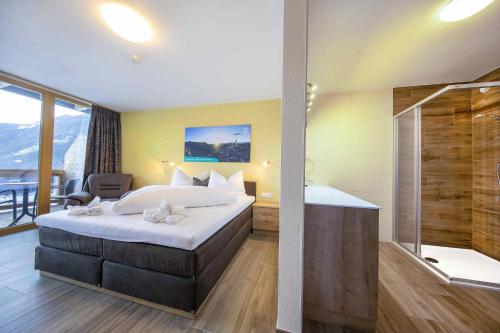克里姆尔Hotel Krimml的酒店客房配有一张床和淋浴