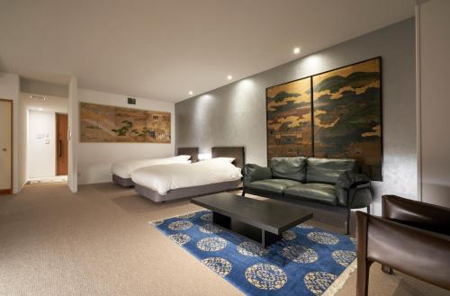 京都京都葵酒店的一间卧室配有一张床、一张沙发和一张桌子