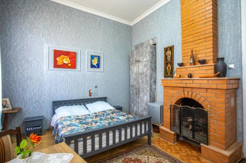 库塔伊西Gantiadi的一间卧室配有一张床和一个砖砌壁炉