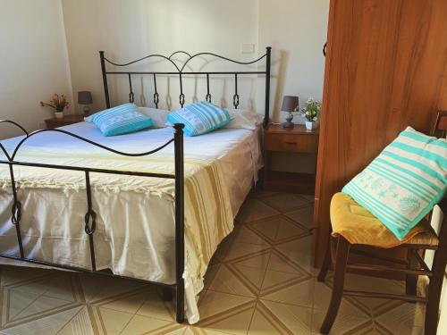丽都玛里尼SoleMareSalento Pt的一间卧室配有一张带蓝色枕头的床和一把椅子