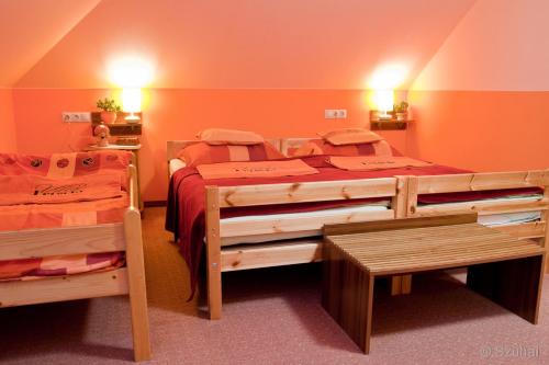 赛特古特哈德佩尔戈拉别墅酒店的橙色墙壁客房中的两张单人床